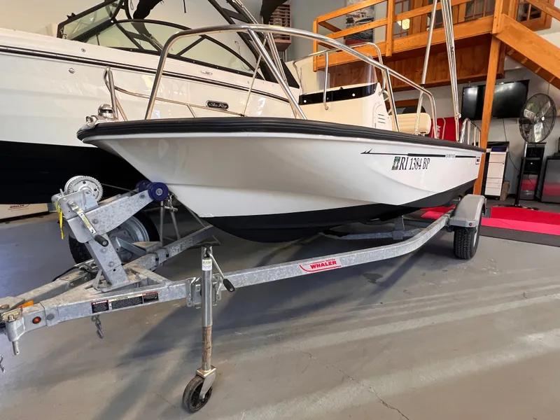 Slide: The Image of 2023 Boston Whaler 150 Montauk on trailer in a garage. - 0