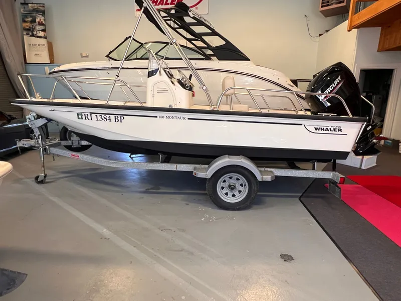 Slide: The Image of Boston Whaler 150 Montauk 2023 on trailer in a garage. - 21