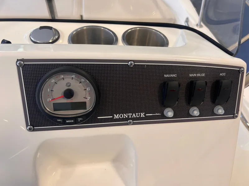 Slide: The Image of Dashboard of 2023 Boston Whaler 150 Montauk with switches and tachometer. - 8