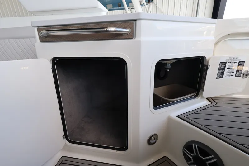 Slide: The Image of Storage compartments and speaker on a 2027 Sea Ray SDX 290 Outboard. - 13