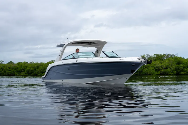 Slide: The Image of A sleek 2027 Sea Ray SLX 310 Outboard boat on calm water. - 29
