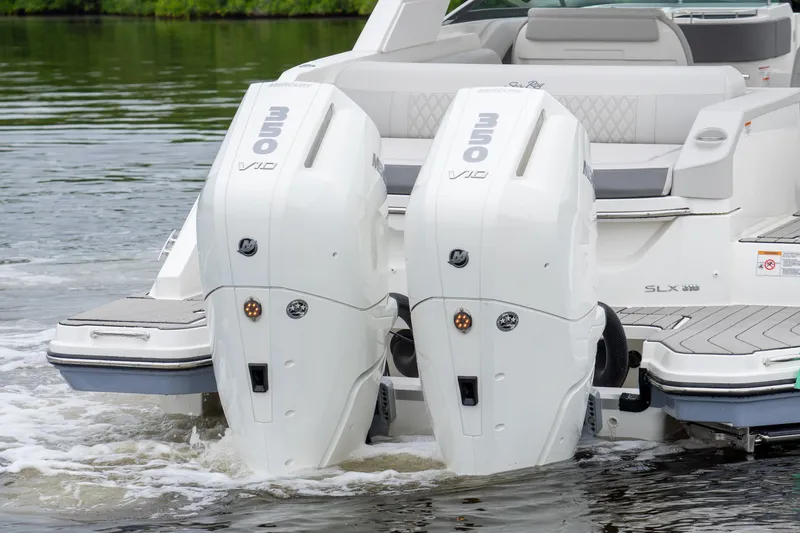 Slide: The Image of Two powerful outboard engines on a Sea Ray SLX 310 boat on calm water. - 4
