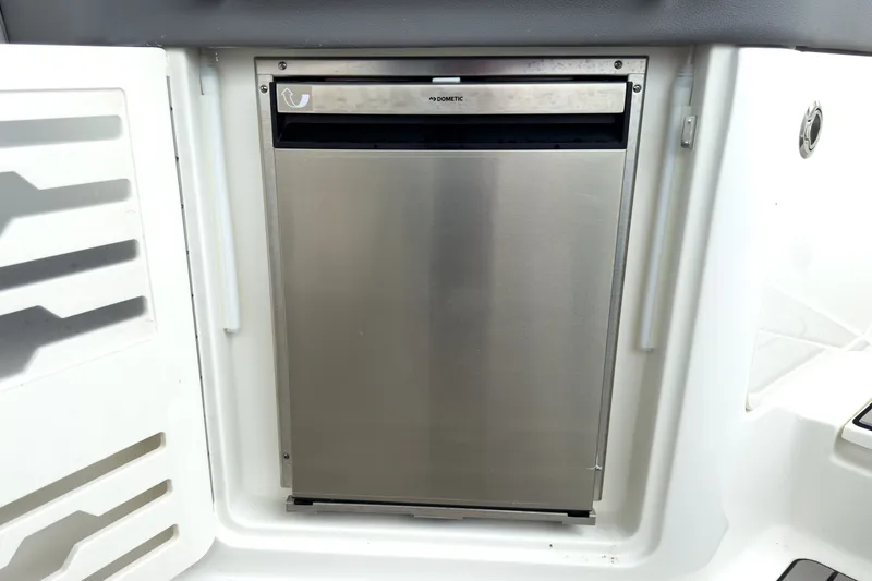 Slide: The Image of A stainless steel refrigerator is integrated into the galley of a Sea Ray SLX 310 Outboard. - 10