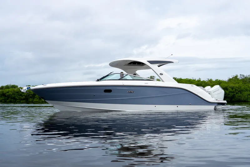 Slide: The Image of A sleek, modern motorboat with a blue hull and white deck on calm water. - 31