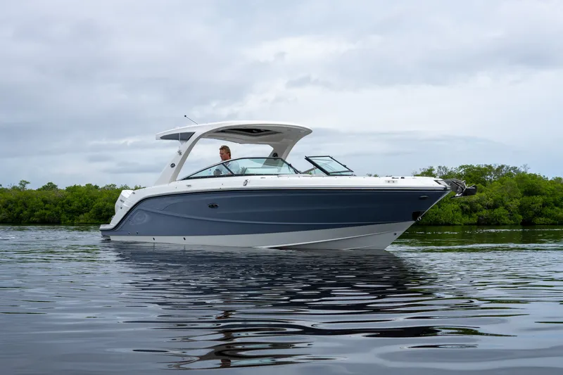 Slide: The Image of A 2027 Sea Ray SLX 310 Outboard cruising on calm water with a cloudy sky in the background. - 28