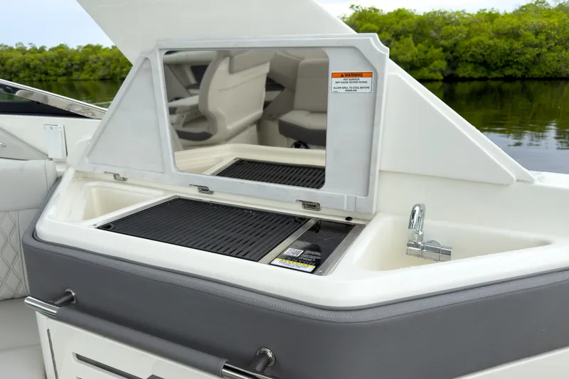 Slide: The Image of The 2027 Sea Ray SLX 310 Outboard features a sleek outdoor kitchen with a sink and grill. - 9