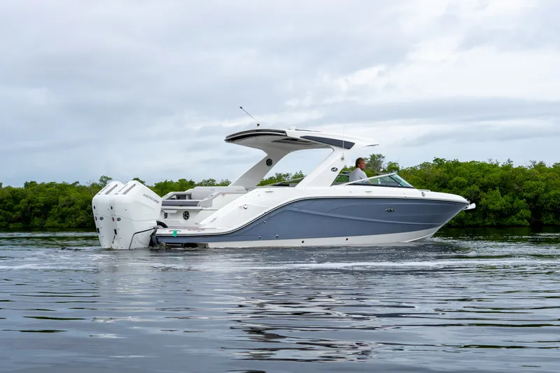 Slide: The Image of A sleek, modern motorboat with dual outboard engines cruising on calm water. - 35