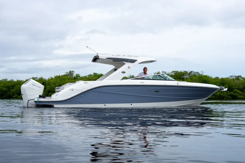 Slide: The Image of A sleek 2027 Sea Ray SLX 310 Outboard boat on calm water. - 26