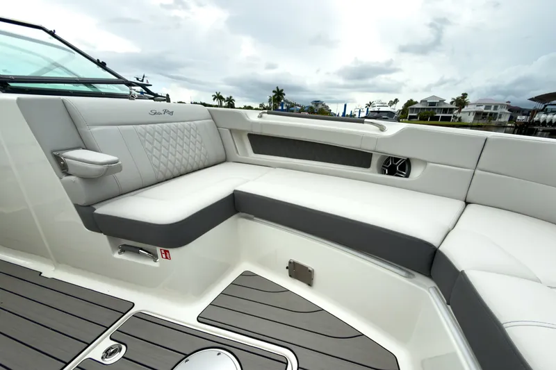 Slide: The Image of The 2027 Sea Ray SLX 310 Outboard features a luxurious, cushioned seating area with gray accents. - 23