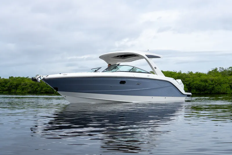 Slide: The Image of A sleek 2027 Sea Ray SLX 310 Outboard boat on calm water. - 2