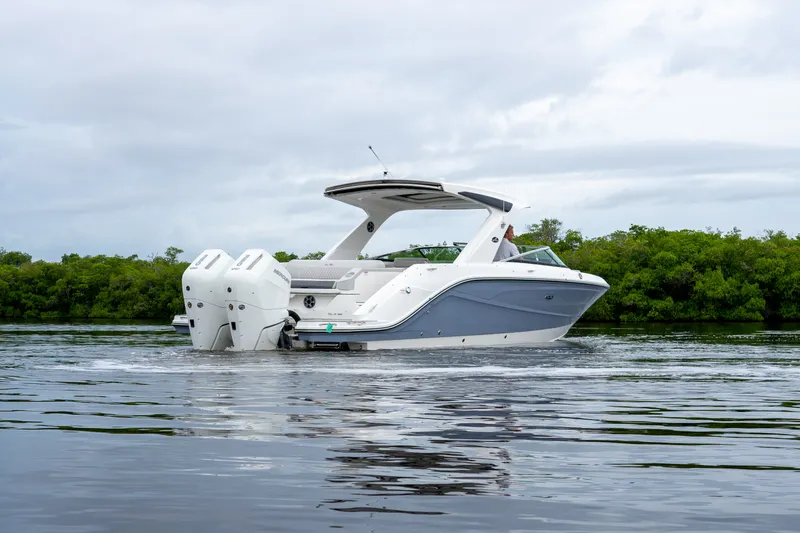 Slide: The Image of A sleek, modern motorboat with dual outboard engines cruising on calm water. - 34
