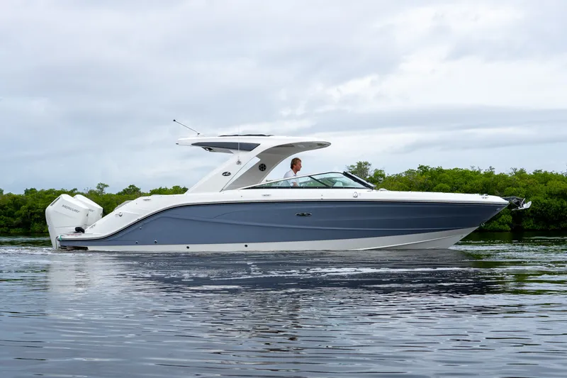 Slide: The Image of A sleek, modern boat with a blue hull and white deck cruising on calm water. - 37