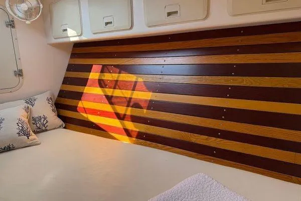 Slide: The Image of Cozy cabin interior of 2011 Reliance 44 sailboat with striped wood paneling and pillows. - 19