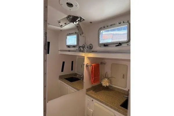 Slide: The Image of Interior of 2011 Reliance 44 yacht bathroom with dual sinks and porthole windows. - 26
