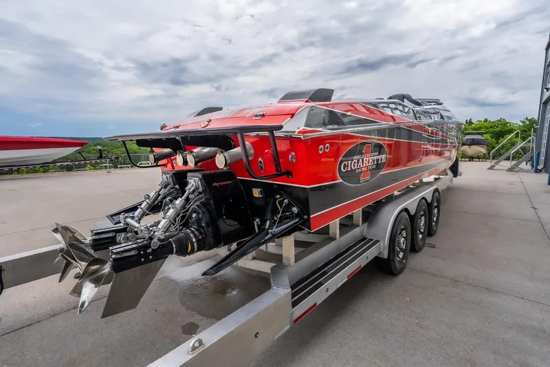 Slide: The Image of 2006 Cigarette 39' Top Gun Unlimited speedboat on trailer, showcasing powerful engines. - 11