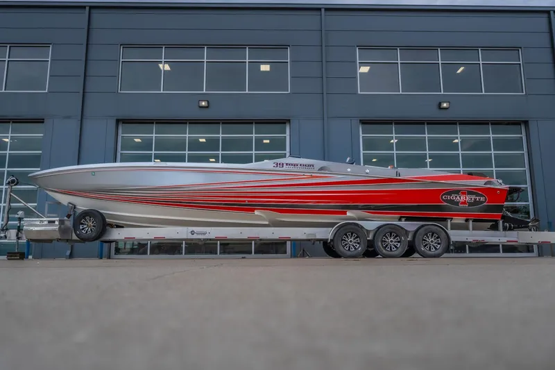 Slide: The Image of 2006 Cigarette 39' Top Gun Unlimited boat on trailer, sleek design with red and silver accents. - 13