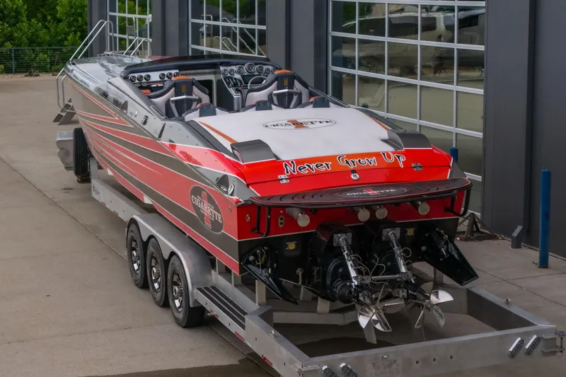 Slide: The Image of 2006 Cigarette 39' Top Gun Unlimited speedboat on trailer, featuring "Never Grow Up" text. - 20