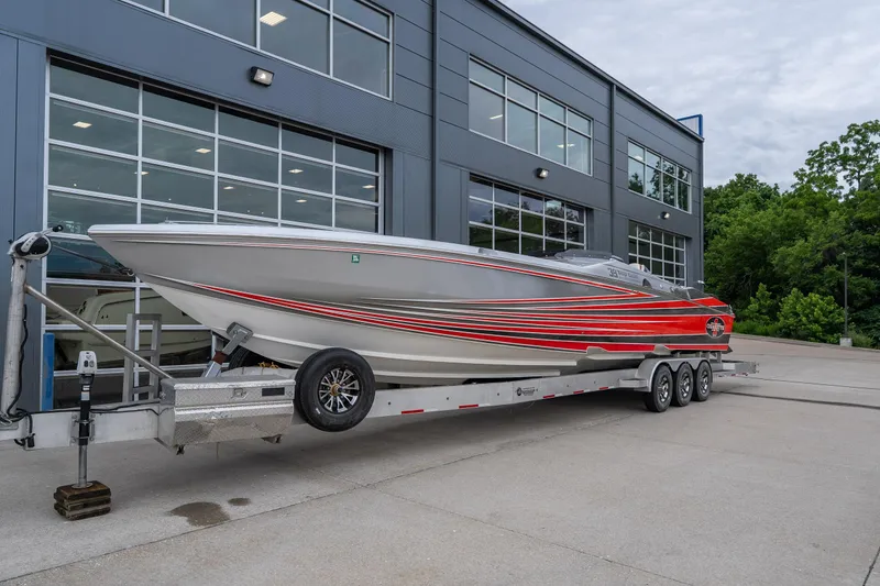 Slide: The Image of 2006 Cigarette 39' Top Gun Unlimited boat on trailer outside modern building. - 24