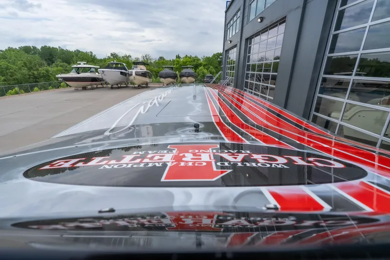 Slide: The Image of 2006 Cigarette 39' Top Gun Unlimited boat with striking red and black design near a marina. - 30