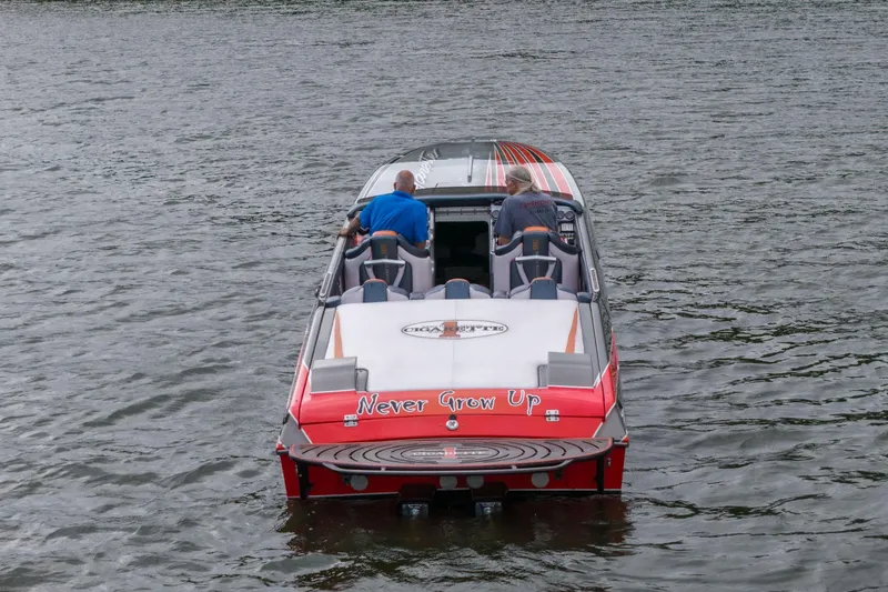 Slide: The Image of 2006 Cigarette 39' Top Gun boat on water, rear view with "Never Grow Up" text. - 6