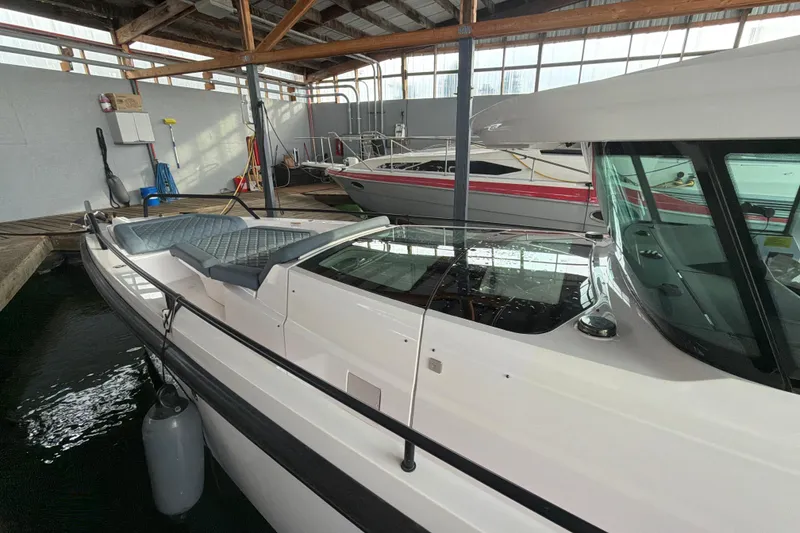 Slide: The Image of 2022 Axopar Brabus 37 XC Cross Cabin boat docked in a marina, showcasing sleek design. - 11