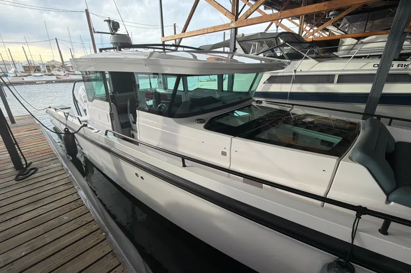 Slide: The Image of 2022 Axopar Brabus 37 XC Cross Cabin docked at marina, showcasing sleek design. - 12