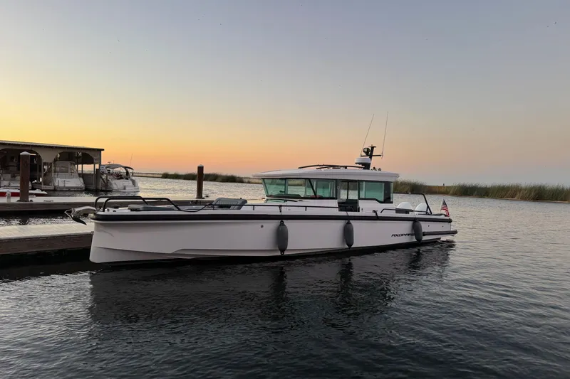 Slide: The Image of 2022 Axopar Brabus 37 XC Cross Cabin boat docked at sunset. - 3