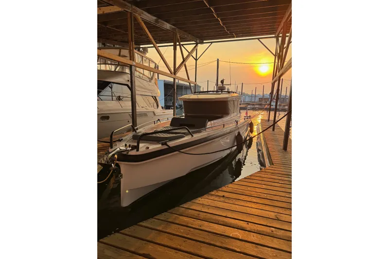 Slide: The Image of 2022 Axopar Brabus 37 XC Cross Cabin docked at sunset. - 4