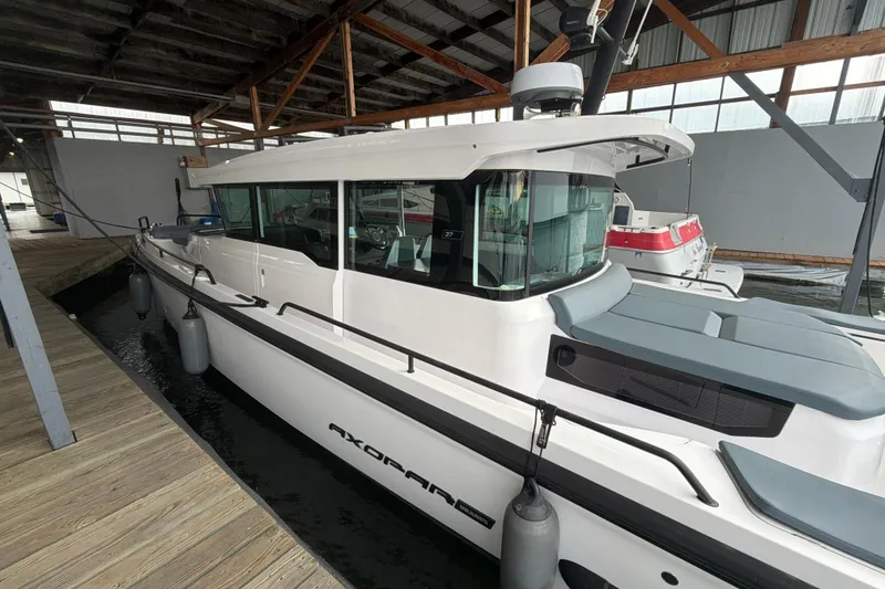 Slide: The Image of 2022 Axopar Brabus 37 XC Cross Cabin docked in a covered marina. - 9