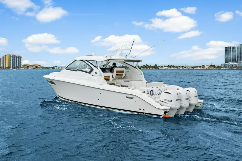 Slide: The Image of Pursuit DC 365 Dual Console 2021 on water near coastal buildings. - 3
