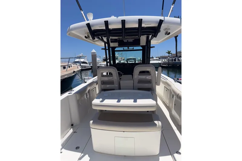 Slide: The Image of 2021 Boston Whaler 330 Outrage boat interior, featuring seating and helm, docked at marina. - 10
