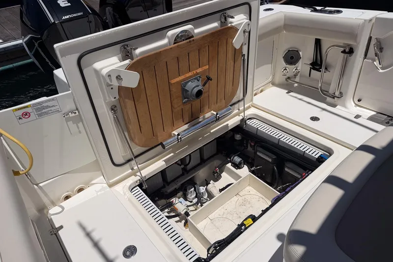 Slide: The Image of 2021 Boston Whaler 330 Outrage boat interior showing open storage compartment and equipment. - 12