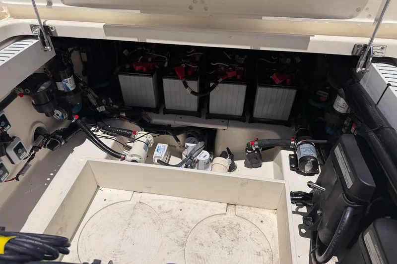 Slide: The Image of 2021 Boston Whaler 330 Outrage engine compartment with batteries and wiring. - 13