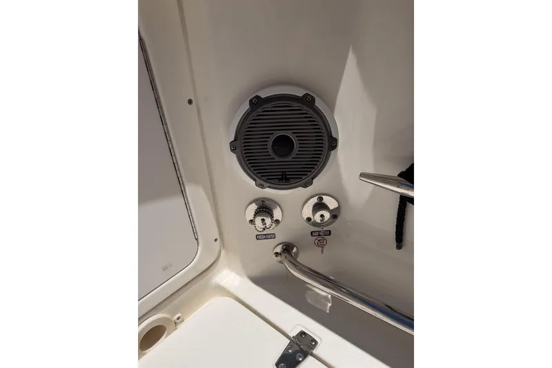 Slide: The Image of 2021 Boston Whaler 330 Outrage boat speaker and water controls detail. - 16