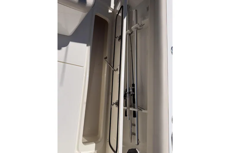 Slide: The Image of Storage compartment on a 2021 Boston Whaler 330 Outrage boat, showcasing fishing rod holders. - 17