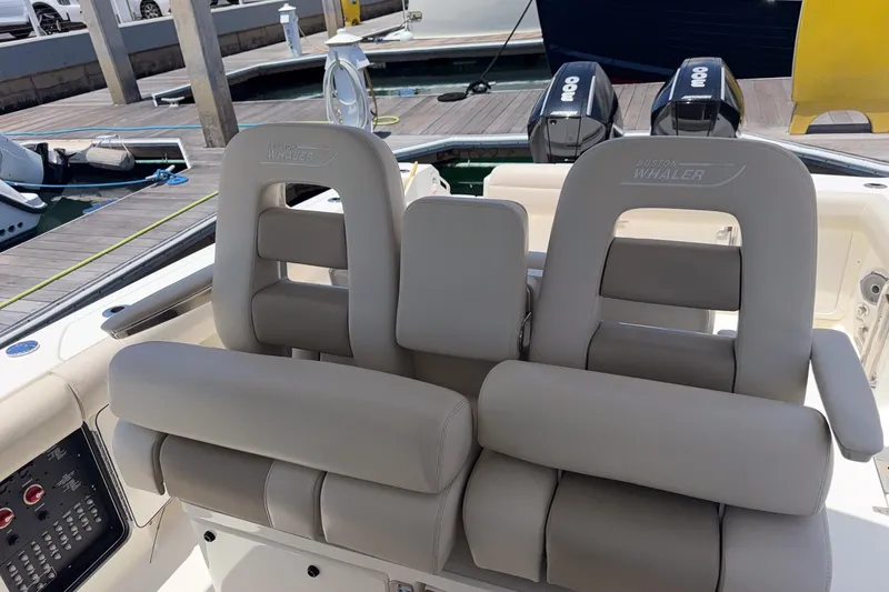 Slide: The Image of 2021 Boston Whaler 330 Outrage boat seats with dual outboard motors at dock. - 19