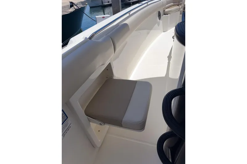 Slide: The Image of 2021 Boston Whaler 330 Outrage boat interior with foldable seat and sleek design. - 21