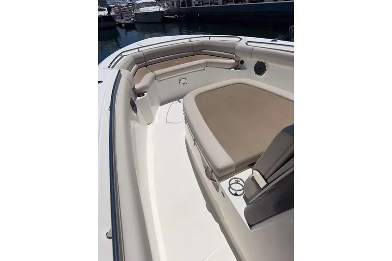 Slide: The Image of 2021 Boston Whaler 330 Outrage boat interior with cushioned seating and cup holders. - 22