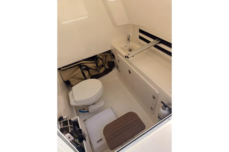 Slide: The Image of 2021 Boston Whaler 330 Outrage cabin interior with toilet and sink. - 24