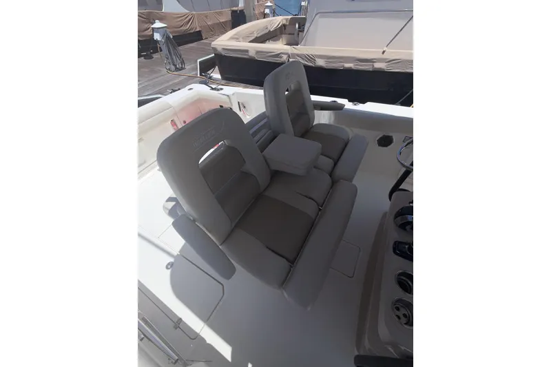 Slide: The Image of 2021 Boston Whaler 330 Outrage boat interior with cushioned seating and console. - 7