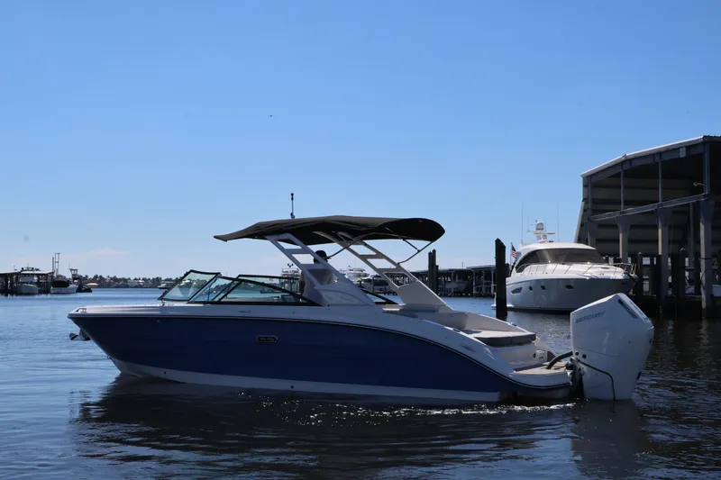 Slide: The Image of 2027 Sea Ray SDX 270 Outboard on calm water, featuring a blue hull and black canopy. - 8