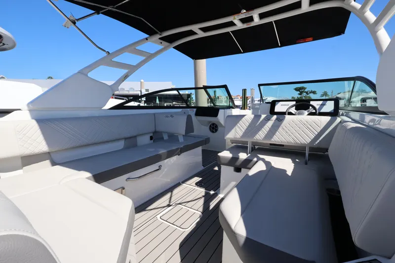 Slide: The Image of The image shows the interior of a 2027 Sea Ray SDX 270 Outboard boat with white seating and a black sunshade. - 15