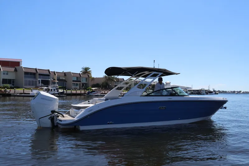 Slide: The Image of 2027 Sea Ray SDX 270 Outboard on calm water near a residential area. - 3