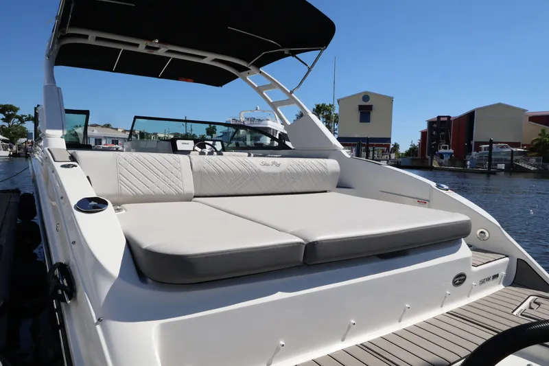 Slide: The Image of The image shows a Sea Ray SDX 270 Outboard boat with comfortable lounging areas in a marina. - 13