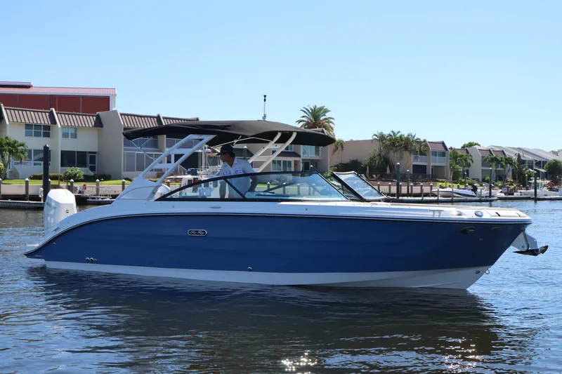 Slide: The Image of A blue 2027 Sea Ray SDX 270 Outboard boat on calm water near a residential area. - 1