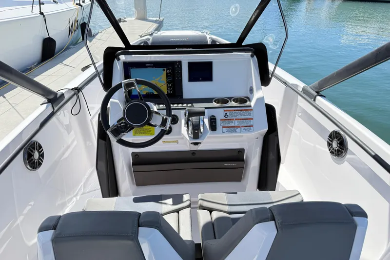 Slide: The Image of 2022 Axopar 22 T-Top boat cockpit with steering wheel and navigation display. - 14