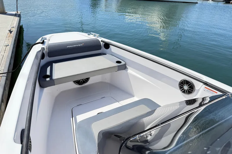 Slide: The Image of 2022 Axopar 22 T-Top boat interior with seating, docked by calm water. - 15