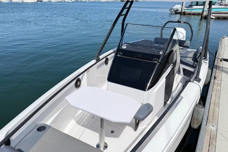 Slide: The Image of 2022 Axopar 22 T-Top boat docked, featuring sleek design and spacious seating area. - 16