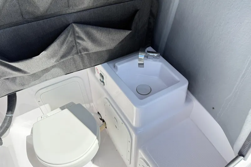 Slide: The Image of 2022 Axopar 22 T-Top boat interior with compact sink and toilet. - 18