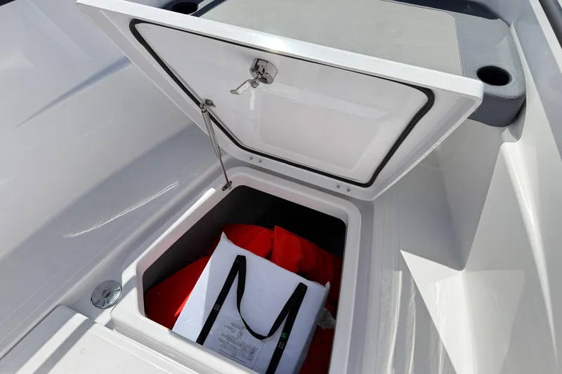 Slide: The Image of Open storage compartment on 2022 Axopar 22 T-Top boat with safety gear inside. - 19